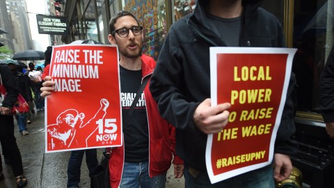 Fast-food workers hold placards in support to an increase of the fastfood workers minimun wage in New York, May 15, 2014. Fast-food workers around the world staged a global protest actions to demand an increase of their minimum wage to 15 USD an hour. AFP PHOTO/Emmanuel Dunand (Photo credit should read EMMANUEL DUNAND/AFP via Getty Images)