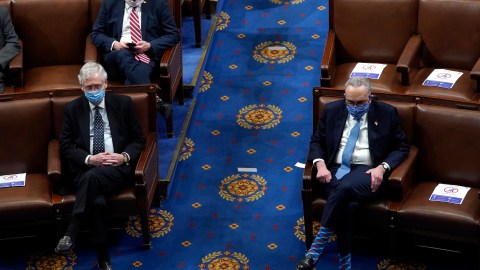 WASHINGTON, DC - JANUARY 06: U.S. Senate Majority Leader Mitch McConnell (L) (R-KY) looks on with U.S. Senate Minority Leader Chuck Schumer (L) (in the House Chamber during a reconvening of a joint session of Congress on January 06, 2021 in Washington, DC. Members of Congress returned to the House Chamber after being evacuated when protesters stormed the Capitol and disrupted a joint session to ratify President-elect Joe Biden's 306-232 Electoral College win over President Donald Trump. (Photo by Drew Angerer/Getty Images)