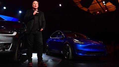 Tesla CEO Elon Musk speaks beside the just unveiled new Tesla Model Y (R) in Hawthorne, California on March 14, 2019. (Photo by Frederic J. BROWN / AFP) (Photo credit should read FREDERIC J. BROWN/AFP via Getty Images)