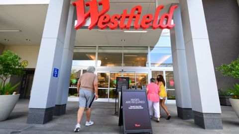 People walk past a sign reminding shoppers of the mask requirement while entering the Westfield Santa Anita shopping mall on June 12, 2020 in Arcadia, California, as Phase 3 in Los Angeles County's battle with the coronavirus pandemic is underway with businesses reopening. (Photo by Frederic J. BROWN / AFP) (Photo by FREDERIC J. BROWN/AFP via Getty Images)