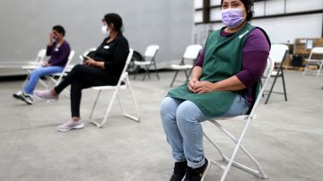 RIVERSIDE, CALIFORNIA - APRIL 05: Workers sit in the observation area after receiving a one shot dose of the Johnson & Johnson COVID-19 vaccine at a clinic geared toward agriculture workers organized by TODEC on April 05, 2021 in Riverside, California. TODEC Legal Center is an immigrant advocacy organization which is traveling to agriculture sites in Southern California to educate and vaccinate farmworkers while dispelling myths about the vaccines. Essential agriculture workers are among the most likely to contract Covid in California as they often work closely together, lack health insurance, and reside in crowded housing conditions. (Photo by Mario Tama/Getty Images)