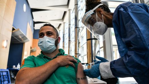 Healthcare worker Caryn Blair (R) administers a Covid-19 vaccine to Nicolas Gonzalez Marcelino at Florida Memorial University Vaccination Site in Miami Gardens, Florida on April 14, 2021. - Florida Division of Emergency Management has opened a new permanent vaccination site at Florida Memorial University. The walk-up site will administer 200 doses of Moderna vaccine per day to any Florida resident over the age of 18. (Photo by CHANDAN KHANNA / AFP) (Photo by CHANDAN KHANNA/AFP via Getty Images)