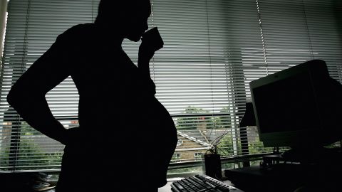 LONDON - JULY 18:  In this photo illustration a pregnant woman is seen stood at the office work station on July 18, 2005 in London, England. Under plans to revise paid maternity leave, an exteneded period of six to nine months will be offered for maternity leave from 2007. (Photo illustration by Daniel Berehulak/Getty Images)