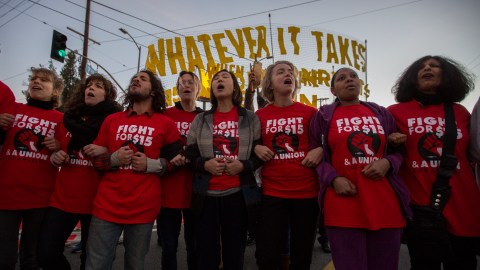 LOS ANGELES, CA - NOVEMBER 29: Striking McDonald's restaurant employees lock arms in an intersection before being arrested, after walking off the job to demand to demand a $15 per hour wage and union rights during nationwide 'Fight for $15 Day of Disruption' protests on November 29, 2016 in Los Angeles, California. Police made 40 peaceful arrests. Protest rallies are expected in nearly 20 airports and outside restaurants in numerous cities, according to organizers. (Photo by David McNew/Getty Images)