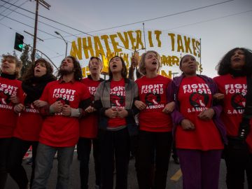 LOS ANGELES, CA - NOVEMBER 29: Striking McDonald's restaurant employees lock arms in an intersection before being arrested, after walking off the job to demand to demand a $15 per hour wage and union rights during nationwide 'Fight for $15 Day of Disruption' protests on November 29, 2016 in Los Angeles, California. Police made 40 peaceful arrests. Protest rallies are expected in nearly 20 airports and outside restaurants in numerous cities, according to organizers.  (Photo by David McNew/Getty Images)