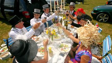 Racegoers enjoy lunch at Ascot racecourse on the first day of Royal Ascot in southern England, on June 17, 2008. Royal Ascot, the annual British parade of horses, hats and high society, got under way Tuesday with organisers warning racegoers to follow its dress code or risk being thrown out. The racing meet, which has been running for nearly 300 years and is a favourite with Queen Elizabeth II, is traditionally a high society affair which ranks the Henley rowing regatta and Glyndebourne opera for prestige. AFP PHOTO/CARL DE SOUZA  (Photo credit should read CARL DE SOUZA/AFP via Getty Images)