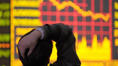 A man looks at the electronic board showing downward graph of share prices index at a securities company in Chengdu, in China's southwestern province of Sichuan, on March 18, 2008. Chinese share prices closed 3.96 percent lower March 18 as sentiment was dampened by inflation concerns and surging prices of raw materials, dealers said. AFP PHOTO/LIU Jin (Photo credit should read LIU JIN/AFP via Getty Images)