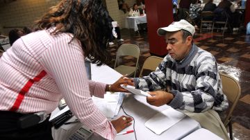 CHICAGO - OCTOBER 17: Community Economic Development Association (CEDA) worker Cynthia White (L) helps a Chicago resident with paperwork at a city Winter Assistance Event organized by the State of Illinois, Cook County, City of Chicago and other local officials October 17, 2005 in Chicago, Illinois. The program for the city residents, known as the Low Income Home Energy Assistance Program, (LIHEAP) is meant to help low-income residents with assistance on paying their bills through the upcoming winter season.  (Photo by Tim Boyle/Getty Images)