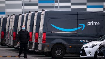 An Amazon employee walks by an Amazon Prime delivery truck in the company's premises in Brandizzo, near Turin, March 22, 2021. - 9,500 warehouse workers and 15,000 drivers of Amazon are on strike for the first time in Italy to claim better working conditions. (Photo by Marco Bertorello / AFP) (Photo by MARCO BERTORELLO/AFP via Getty Images)