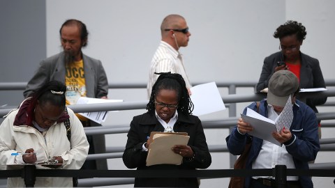 SAN FRANCISCO, CA - AUGUST 15: Job seekers fill out applications as they wait in line to enter a job fair at a new Target retail store on August 15, 2013 in San Francisco, California. Hundreds of job seekers applied for jobs during a job fair to staff a new Target City store. According to a report by the Labor Department, the number of people seeking first time unemployment benefits fell to the lowest level since 2007 with initial jobless claims decreasing by 15,000 to 320,000. (Photo by Justin Sullivan/Getty Images)