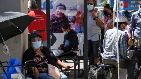 People wait for a bus in the largely Latino neighborhood of East Los Angeles, August 7, 2020 in Los Angeles, California during the coronavirus pandemic. - California is experiencing a statewide spike in COVID-19 infections among Latinos, both in urban areas as well as rural, farm-working communities according to reports in the Los Angeles Times. (Photo by Robyn Beck / AFP) (Photo by ROBYN BECK/AFP via Getty Images)