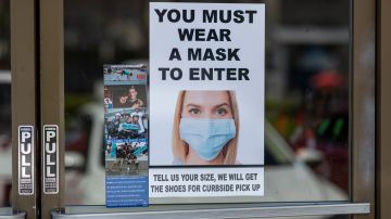 GLENDALE, CA - MAY 27: Masks are required for entry to a Shoe City store as Los Angeles County retail businesses reopen while the COVID-19 pandemic continues on May 27, 2020 in Glendale, Californias latest guidelines and allow the resumption of in-store shopping at low-risk retail stores, faith-based services, drive-in theaters and other recreational activities with reduced capacities and social distancing restrictions, starting today. Not reopening yet are personal services locations like hair salons and dining in at restaurants.  (Photo by David McNew/Getty Images)