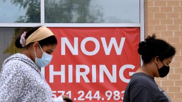 Women walk past by a "Now Hiring" sign outside a store on August 16, 2021 in Arlington, Virginia. (Photo by Olivier DOULIERY / AFP) (Photo by OLIVIER DOULIERY/AFP via Getty Images)