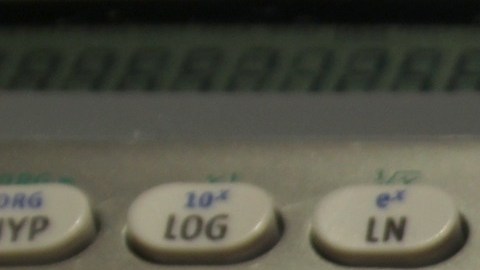 Foto de una calculadora sobre una hoja con dígitos y cifras