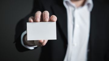Foto de una persona mostrando una tarjeta en blanco