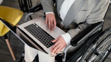 Foto de una persona en silla de ruedas usando una laptop