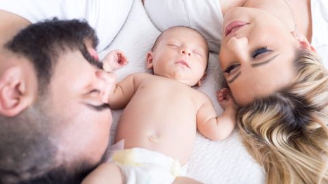 Foto de una mujer y un hombre junto a un bebé