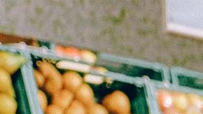 Foto de una mujer observando frutas en un supermercado
