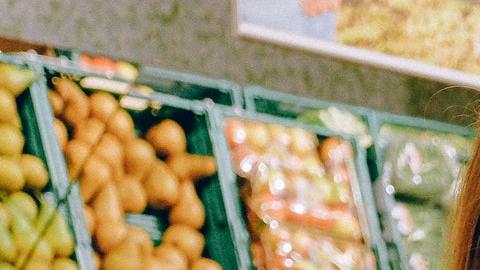 Foto de una mujer observando frutas en un supermercado
