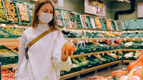 Foto de una mujer observando frutas en un supermercado