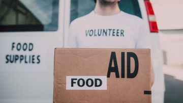 Foto de un voluntario cargando una caja de comida.