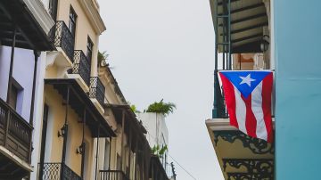 Foto de la bandera de Puerto Rico colgando del balcón de una casa