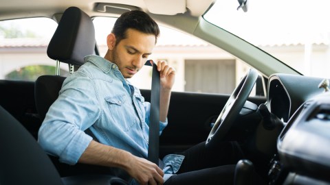 Foto de un hombre ajustándose el cinturón de seguridad en el auto