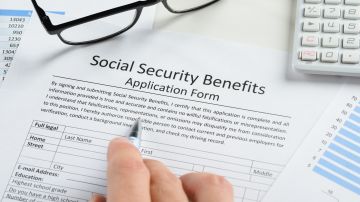 Foto de la mano de una persona sobre un formulario del Seguro Social