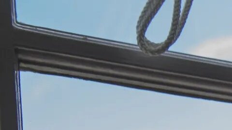 Foto de una mujer mayor mirando desde su ventana