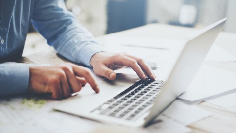 Foto de un hombre escribiendo en una laptop