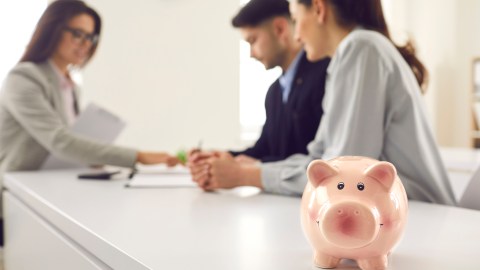 Foto de una pareja siendo atendida por un agente bancario