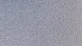 Foto de las manos de una persona sosteniendo una tarjeta y un teléfono celular frente a una laptop