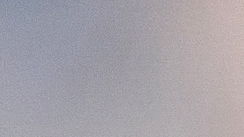 Foto de las manos de una persona sosteniendo una tarjeta y un teléfono celular frente a una laptop