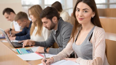 Foto de varios estudiantes escribiendo durante una clase