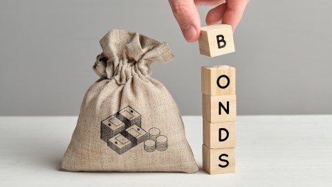Foto de la mano de una persona formando la palabra "bonds" con bloques