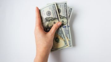 Foto de la mano de una persona sosteniendo dinero