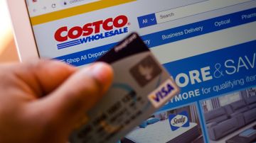 Foto de la mano de una persona con una tarjeta de crédito comprando en Costo