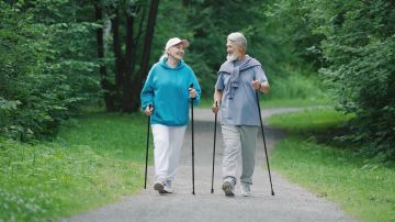 Una pareja de adultos mayores camina en un parque de Estados Unidos.