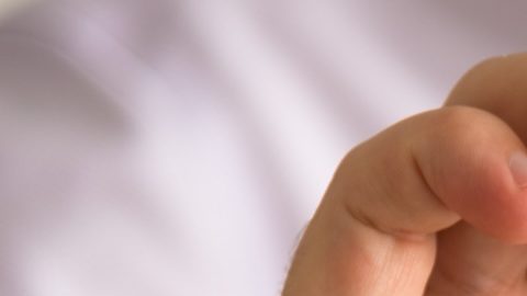 Primer plano de un hombre de negocios sosteniendo una tarjeta con el mensaje NÚMERO DE CUENTA BANCARIA INTERNACIONAL IBAN,