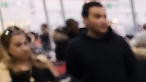 Una mano que sostiene un recibo y una tarjeta de membresía de Costco en el almacén de Costco.