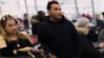 Una mano que sostiene un recibo y una tarjeta de membresía de Costco en el almacén de Costco.