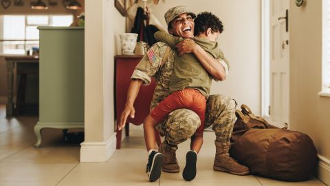 Emocionada madre militar abrazando a su hijo después de regresar a casa del ejército