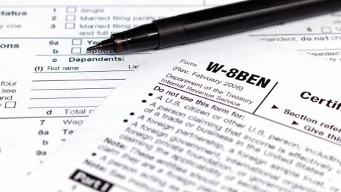 Bolígrafo negro sobre el formulario de impuestos W-8BEN.