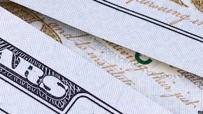 Aplicación móvil con el logotipo de TikTok en la pantalla del teléfono inteligente iPhone con dólares en primer plano.