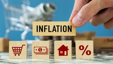 Palabra de INFLACIÓN en un cubo de madera con gráfico comercial.