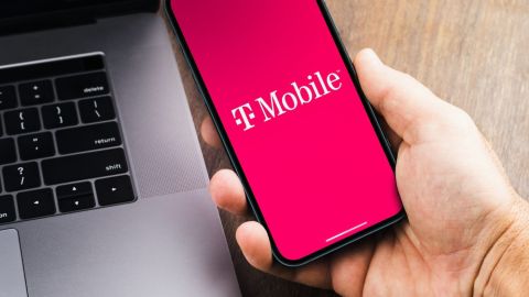 Mano sosteniendo un teléfono celular con la app de T-Mobile en la pantalla.