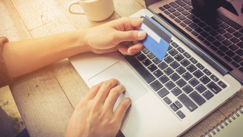 Hombre sostiene una tarjeta de crédito de saldo cero o zero balance card en inglés.