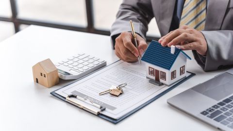 Gerente de agente inmobiliario trabajando en documentos, hipotecas y propiedades.