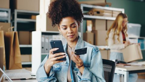 Mujer usa su tarjeta de crédito comercial para su pequeña empresa.