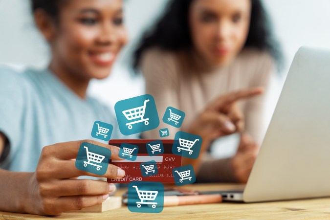 Par de mujeres se prepara para elegir dónde hacer sus compras en línea.